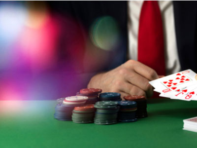 card player sitting at a poker table with chips